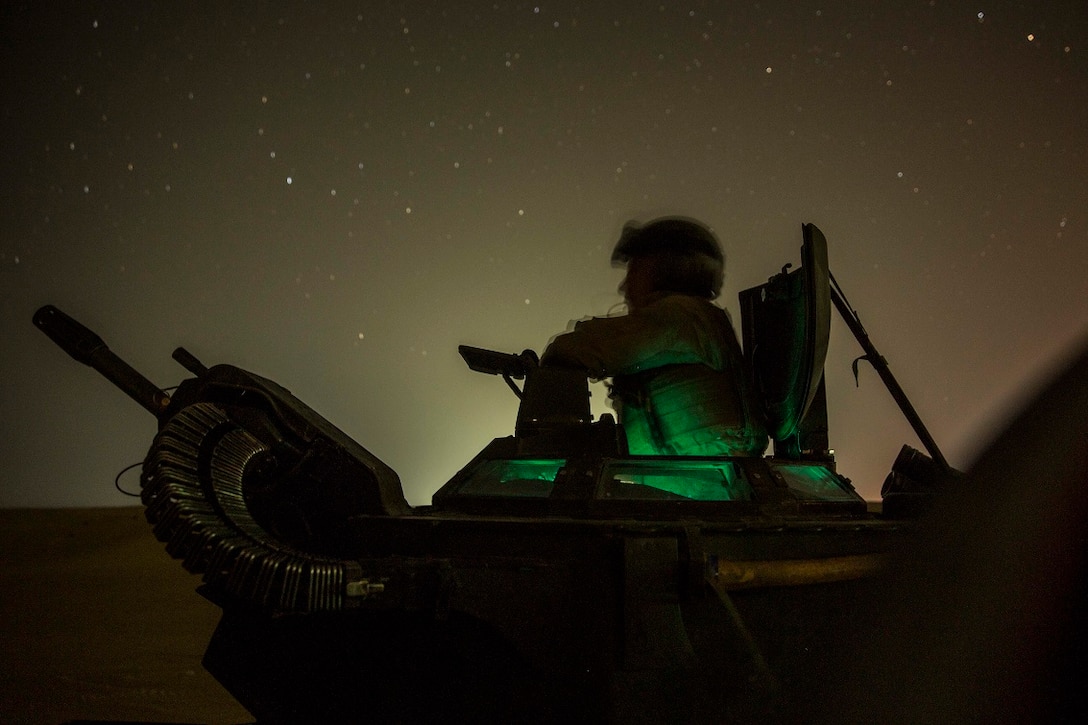 U.S. Marine Cpl. Jeffery Quam waits to start his run at a night live-fire and maneuver exercise in Kuwait, Aug. 19, 2015. Quam is a crew chief with Kilo Company, Battalion Landing Team 3rd Battalion, 1st Marine Regiment, 15th Marine Expeditionary Unit (MEU). During the training, Marines used night vision devices to engage targets with the Browning .50 caliber machine gun at unknown distances from Amphibious Assault Vehicles (AAV-7). Elements of the 15th MEU are ashore in Kuwait for sustainment training to maintain and enhance the skills they developed during their pre-deployment training period.  The 15th MEU is embarked on the Essex Amphibious Ready Group and deployed to maintain regional security in the U.S. 5th Fleet area of operations.