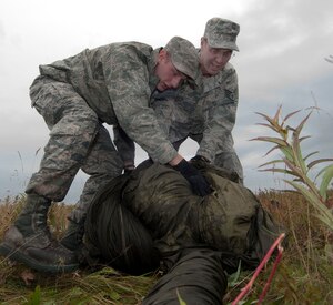 JOINT BASE ELMENDORF-RICHARDSON, Alaska -- Staff Sgt. Josef Lenz (left) and Staff Sgt. Steven Ellis (right), members of the 176th Logistics Readiness Squadron - Air Terminal Operations, recover a deployed cargo parachute after an airdrop at Malamute Drop Zone here, Aug. 16, 2015. Members of the 176th Mission Support Group from approximately 20 different job specialties trained in their wartime mission skills during the four-day Polar Guard 15-1 exercise. (U.S. Air National Guard photo by Capt. John Callahan/ Released.)