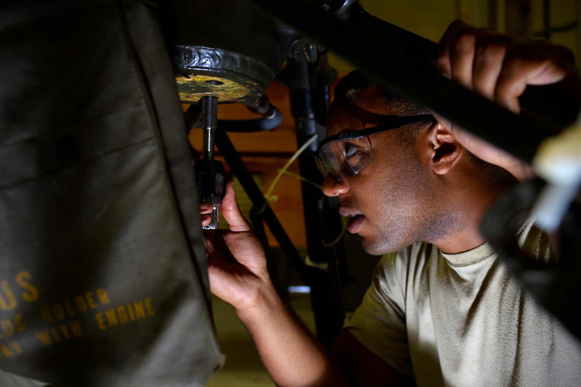Airman 1st Class Dawuud Gibson, aerospace ground equipment journeyman and deployed member of the 36th Maintenance Squadron, adjusts a screw on an aircraft tripod jack Aug. 12, 2015, at Andersen Air Force Base, Guam. The AGE maintainers care for a variety of essential equipment used during aircraft maintenance and preflight operations. (U.S. Air Force photo by Staff Sgt. Alexander W. Riedel/Released)  