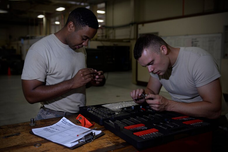 Senior Airman Dawuud Gibson, and Staff Sgt. Orson Lyttle, both aerospace ground equipment technicians with the 36th Maintenance Squadron, assess screw thread on a damaged bolt Aug. 12, 2015, at Andersen Air Force Base, Guam. The AGE maintainers care for a variety of essential equipment used during aircraft maintenance and preflight operations. (U.S. Air Force photo by Staff Sgt. Alexander W. Riedel/Released)  