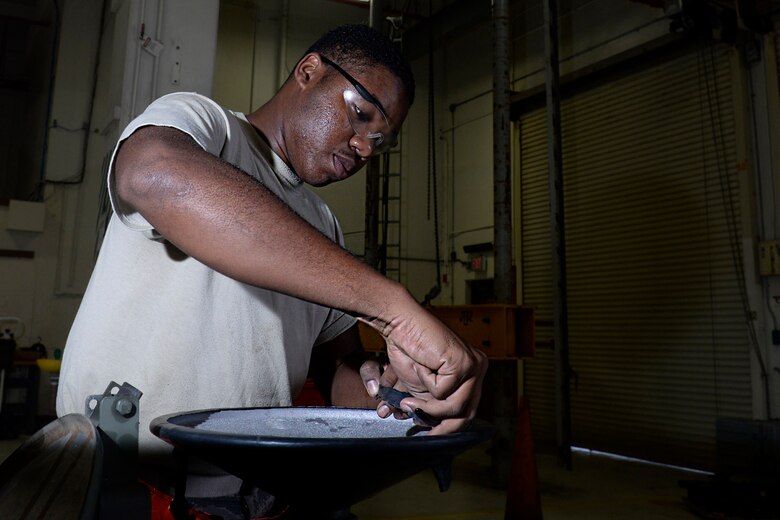 Senior Airman Antonio Simon, aerospace ground equipment journeyman and deployed member of the 36th Maintenance Squadron, installs an improvised rubber seal to a towable jet fuel container Aug. 12, 2015, at Andersen Air Force Base, Guam.  The AGE maintainers care for a variety of essential equipment used during aircraft maintenance and preflight operations. (U.S. Air Force photo by Staff Sgt. Alexander W. Riedel/Released)  