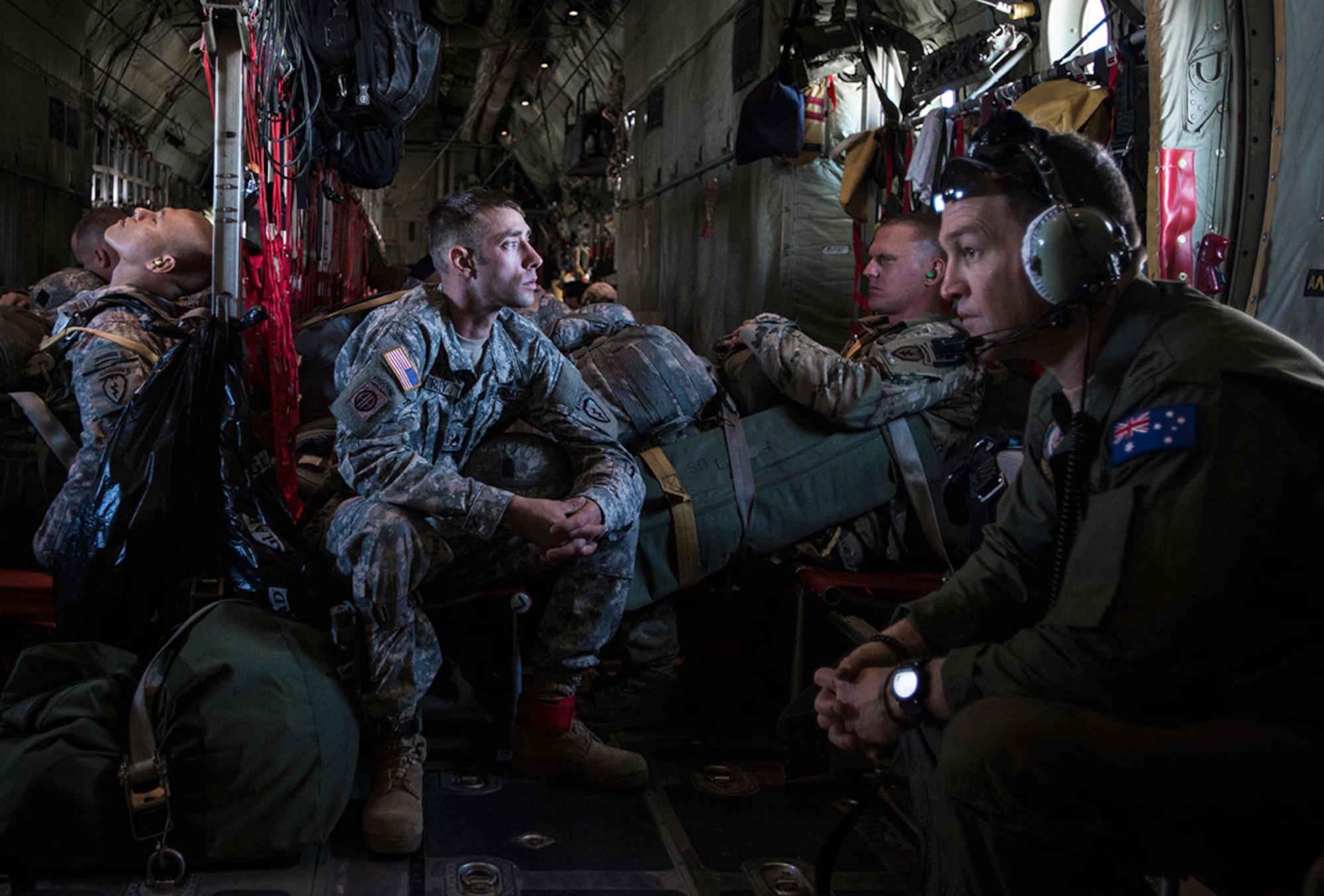 Army Staff Sgt. Colton Hurley (center), a jumpmaster with B Company, 3rd Battalion (Airborne), 509th Infantry Regiment, 4th Brigade Combat Team (Airborne), 25th Infantry Division, stares out the window of an Australian C-130 before a training jump during Red Flag Alaska 15-3 Aug. 11. (U.S. Air Force photo/Staff Sgt. Wes Wright)