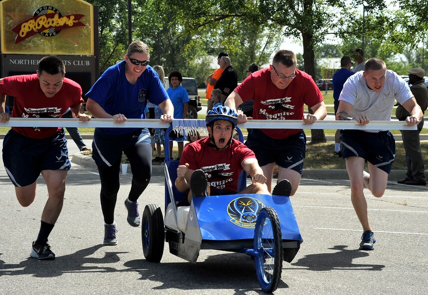 Members of the 69th Reconnaissance Group push Airman Dakota Stantz, 69th Maintenance Squadron aircraft structural maintenance journeyman, to the finish line in the 2015 Summer Bash bed race on Grand Forks Air Force Base, North Dakota, Aug. 20, 2015. The driver had to participate in various tasks during the race in order to complete the course. (U.S. Air Force photo by Airman 1st Class Bonnie Grantham/released)