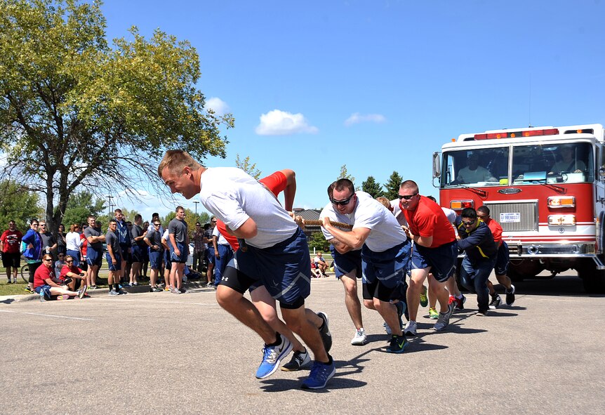 Airmen from the 319th Civil Engineer Squadron on Grand Forks Air Force Base participate in the fire truck pull during the 2015 Summer Bash on Grand Forks AFB, North Dakota, Aug. 20, 2015. Airmen took a break from their routine duties to participate in the Summer Bash events. (U.S. Air Force by Airman 1st Class Bonnie Grantham/released)