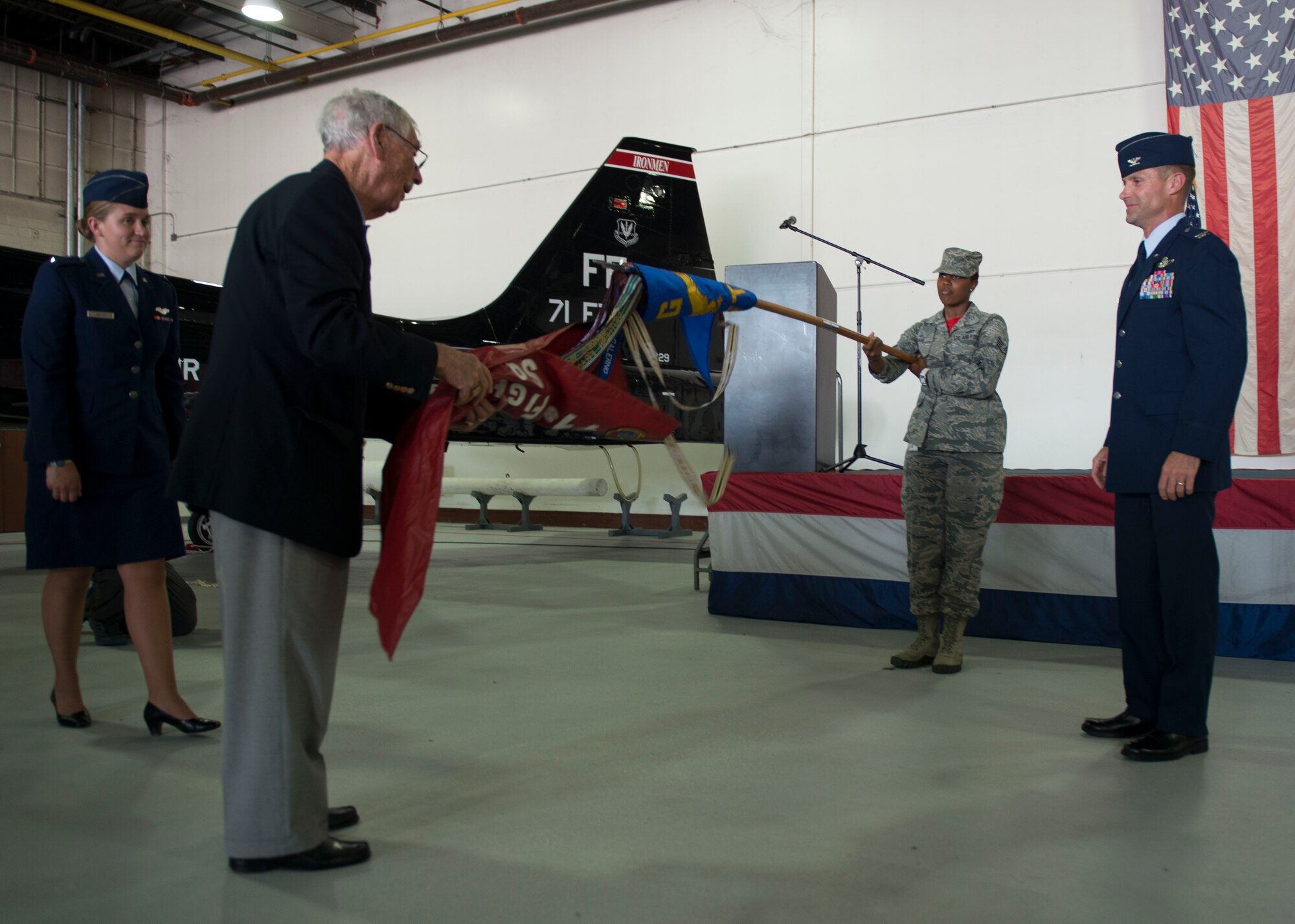 P.E. MacAllister, a former member of the 71st Fighter Squadron, unveils the squadron’s guidon during a reactivation ceremony at Langley Air Force Base, Va., Aug. 21, 2015. Throughout its history, the 71st FS has flown a variety of combat aircraft including the P-38 Lightning, P-80 Shooting Star, F-86 Sabre, F-106 Delta Dart, and F-4 Phantom.  In 1975, the 71st Tactical Fighter Squadron moved to Langley and was equipped with the F-15 Eagle, which it flew for more than 30 years before its deactivation in 2010. (U.S. Air Force photo by Staff Sgt. John D. Strong II/Released)