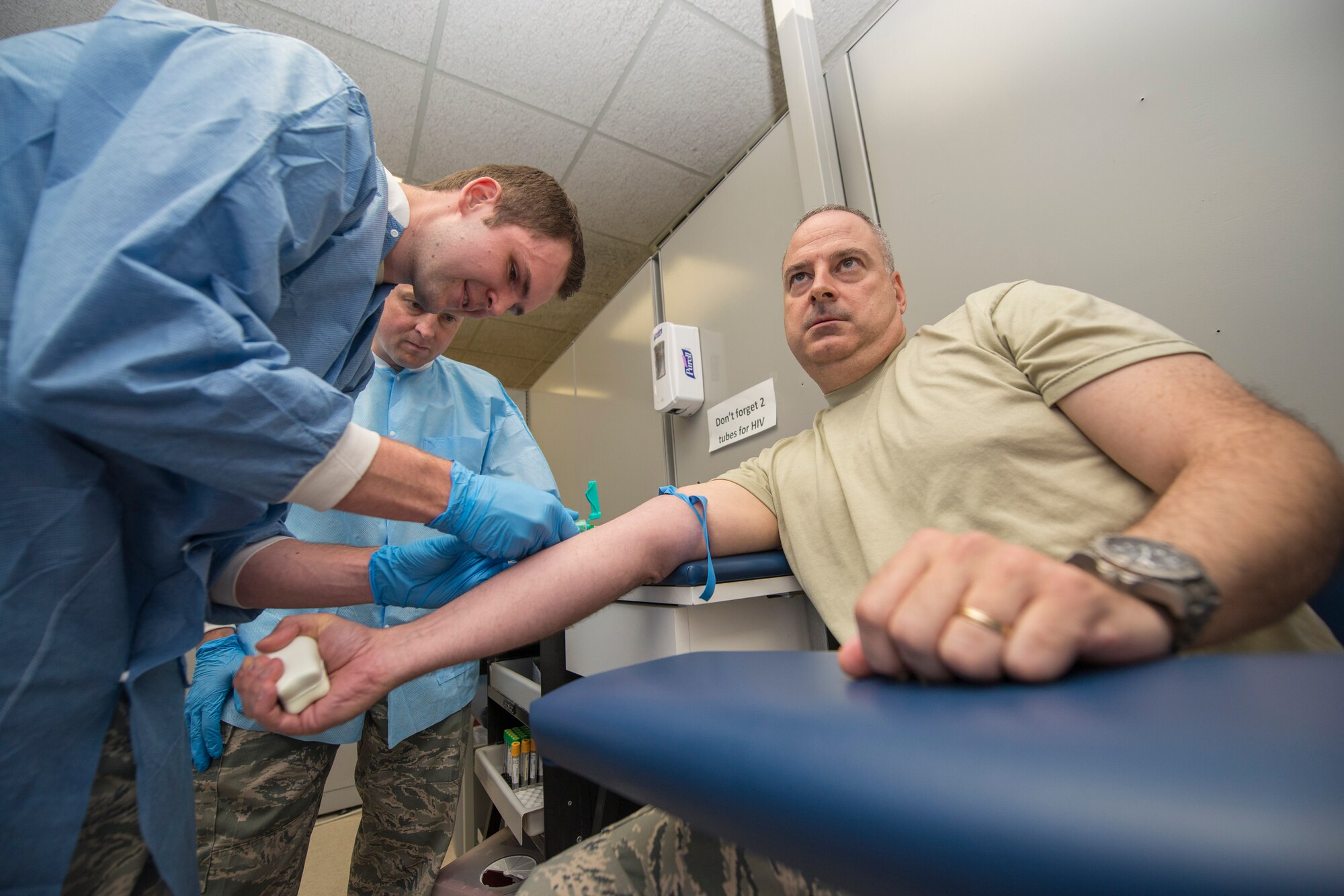 Senior Airman Mason Livermore, a 49th Medical Group medical laboratory technician, draws blood from Col. Paul Willingham, the 49th Medical Group commander, as Col. Robert Kiebler, the 49th Wing commander, watches the process at Holloman Air Force Base, N.M., Aug. 19. Every week the wing commander and the wing command chief visit a different unit to familiarize themselves with the various jobs performed on base, and to get hands-on experience. Livermore informed Kiebler about the phlebotomy processes used in the medical laboratory. (U.S. Air Force photo by Senior Airman Aaron Montoya)