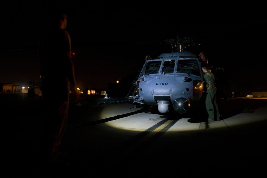 Crew chiefs from the 41st Helicopter Maintenance Unit take off the doors of an HH-60G Pave Hawk before a night flight Aug. 20, 2015, at Moody Air Force Base, Ga. The 41st Rescue Squadron performed the flight without doors to execute aerial target practice with the Pave Hawk’s 50-caliber machine gun. (U.S. Air Force photo by Airman 1st Class Dillian Bamman/Released)