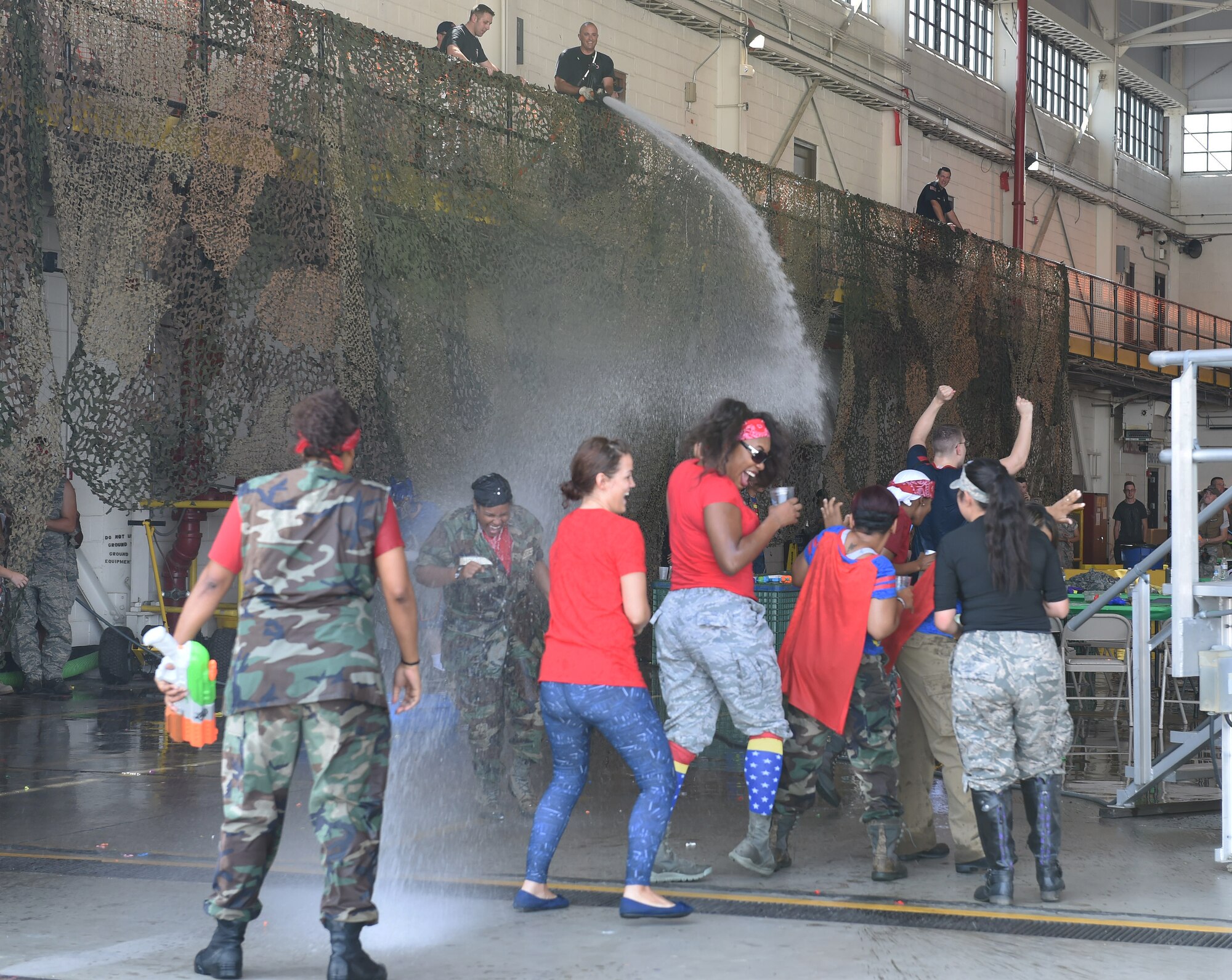 Buckley firefighters spray Combat Dining Out attendees during the event Aug. 21, 2015, at Hangar 909 on Buckley Air Force Base, Colo. Combat Dining Out is an annual event that included water fights, an obstacle course, a grog bowl, food, music, and is a spin on the more formal Combat Dining In, allowing spouses and guests to attend. (U.S. Air Force photo by Airman 1st Class Samantha Meadors/Released)