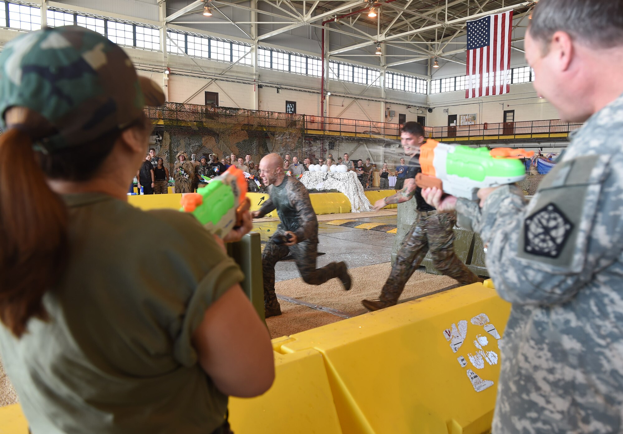 Two Combat Dining Out attendees race in the obstacle course during the event Aug. 21, 2015, at Hangar 909 on Buckley Air Force Base, Colo. Combat Dining Out is an annual event that included water fights, an obstacle course, a grog bowl, food, music, and is a spin on the more formal Combat Dining In, allowing spouses and guests to attend. (U.S. Air Force photo by Airman 1st Class Samantha Meadors/Released)