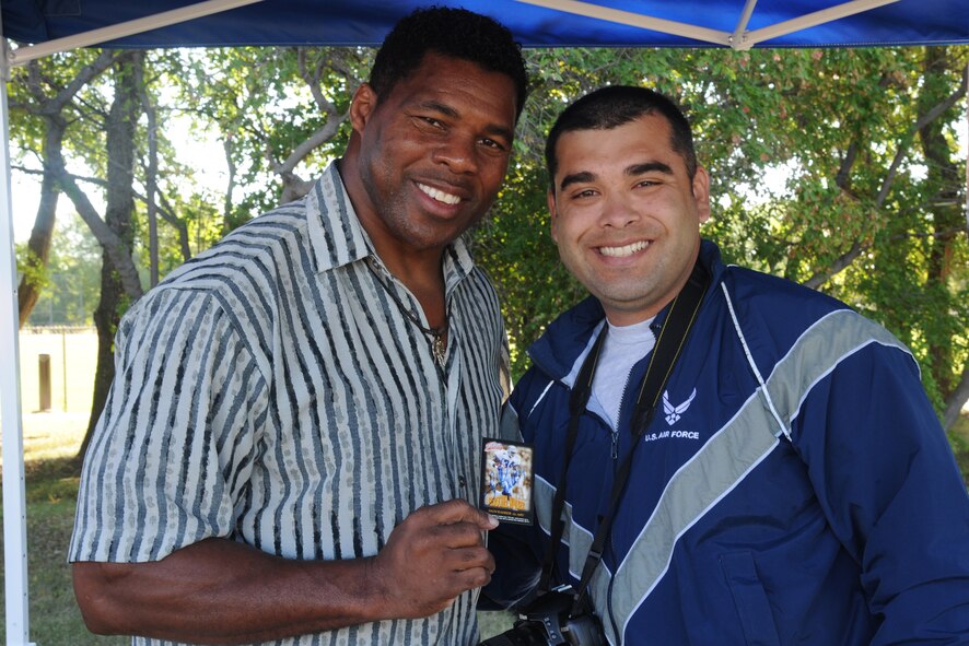 Herschel Walker poses for a photo with Staff Sgt. Luis Loza Gutierrez during a meet and greet session Aug. 20, 2015, at the Summer Bash sports grounds on Grand Forks Air Force Base, N.D. Walker spent the day with Airmen and was the guest speaker at the closing ceremony for the day's events. (U.S. Air Force photo/Senior Airman Desiree Economides)