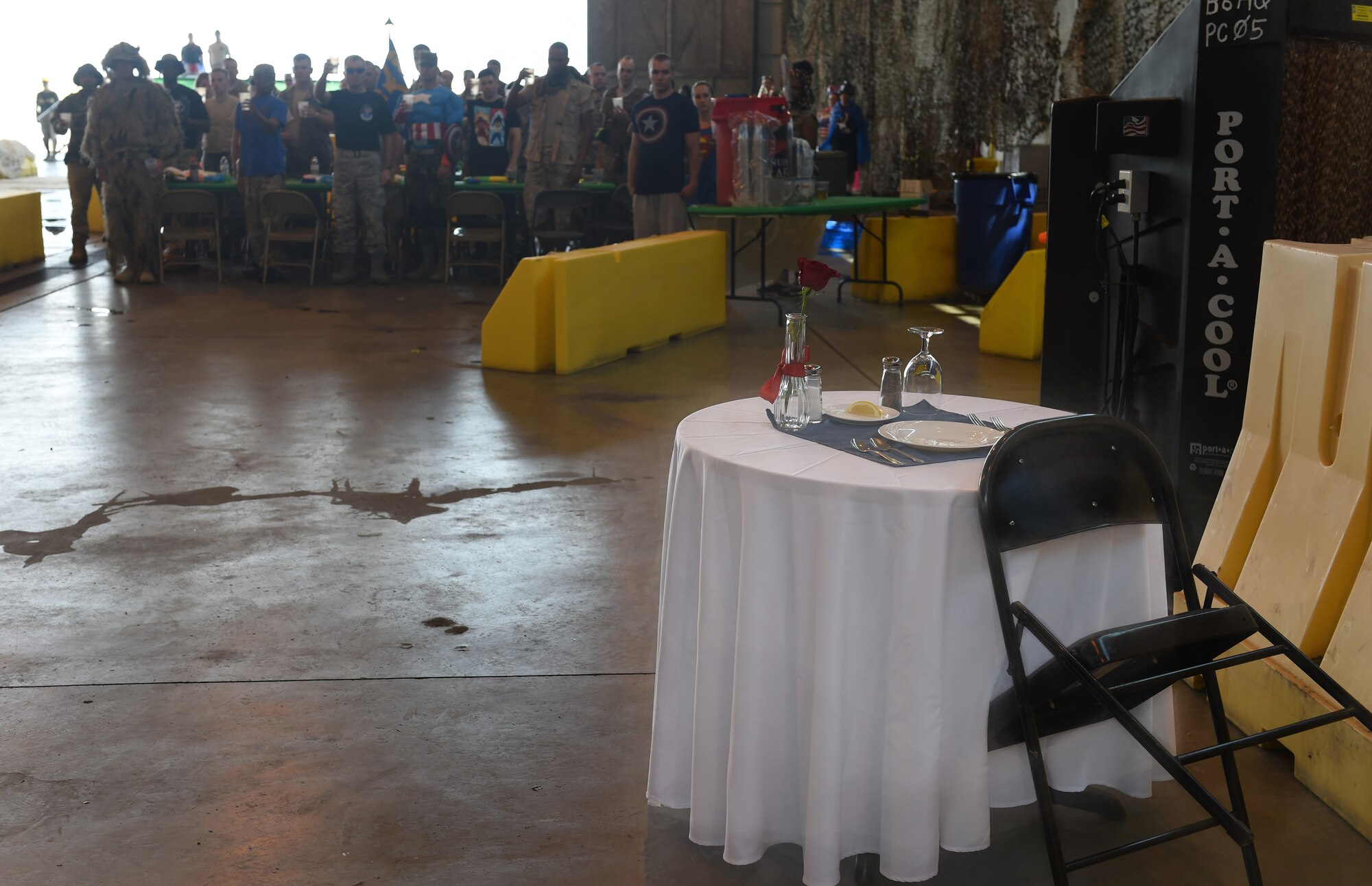 Attendees of Buckley Air Force Base’s Combat Dining Out toast to the Prisoner Of War/Missing In Action table Aug. 21, 2015, at Hangar 909 on Buckley AFB, Colo. The annual event included water fights, an obstacle course, a grog bowl, food, music, and is a variation on the more formal Combat Dining In, allowing spouses and guests to attend. (U.S. Air Force photo by Airman 1st Class Samantha Meadors/Released)