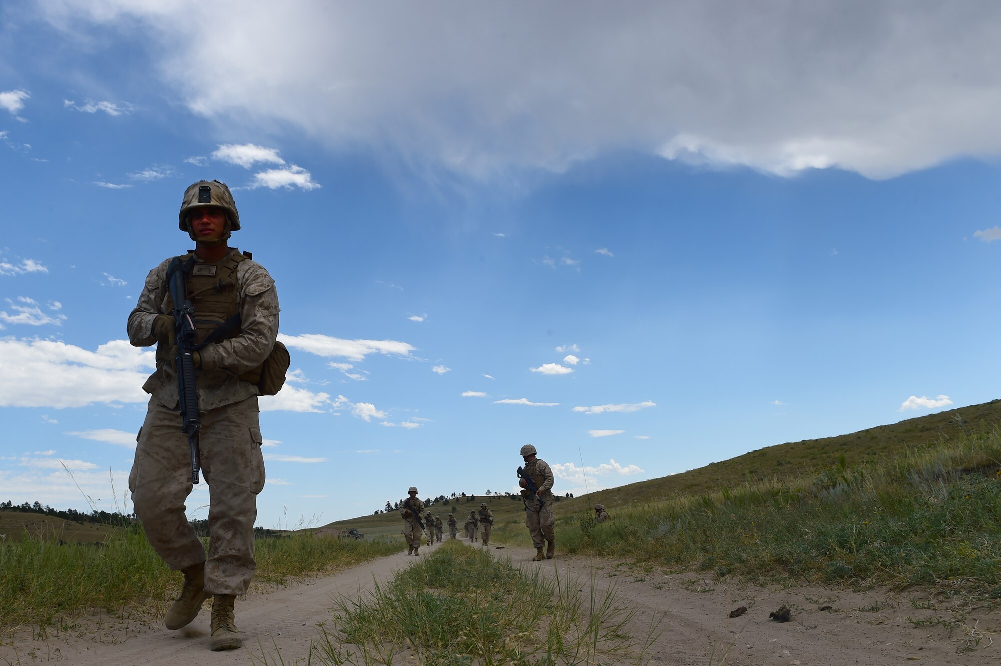 Marines from Quebec Battery, 5th Battalion 14 Marines, patrol around an artillery position Aug. 15, 2015, in Guernsey, Wyoming. The Marines from Q Battery practice patrols to secure an area where guns are emplaced. (U.S. Air Force photo by Airman 1st Class Luke W. Nowakowski/Released)