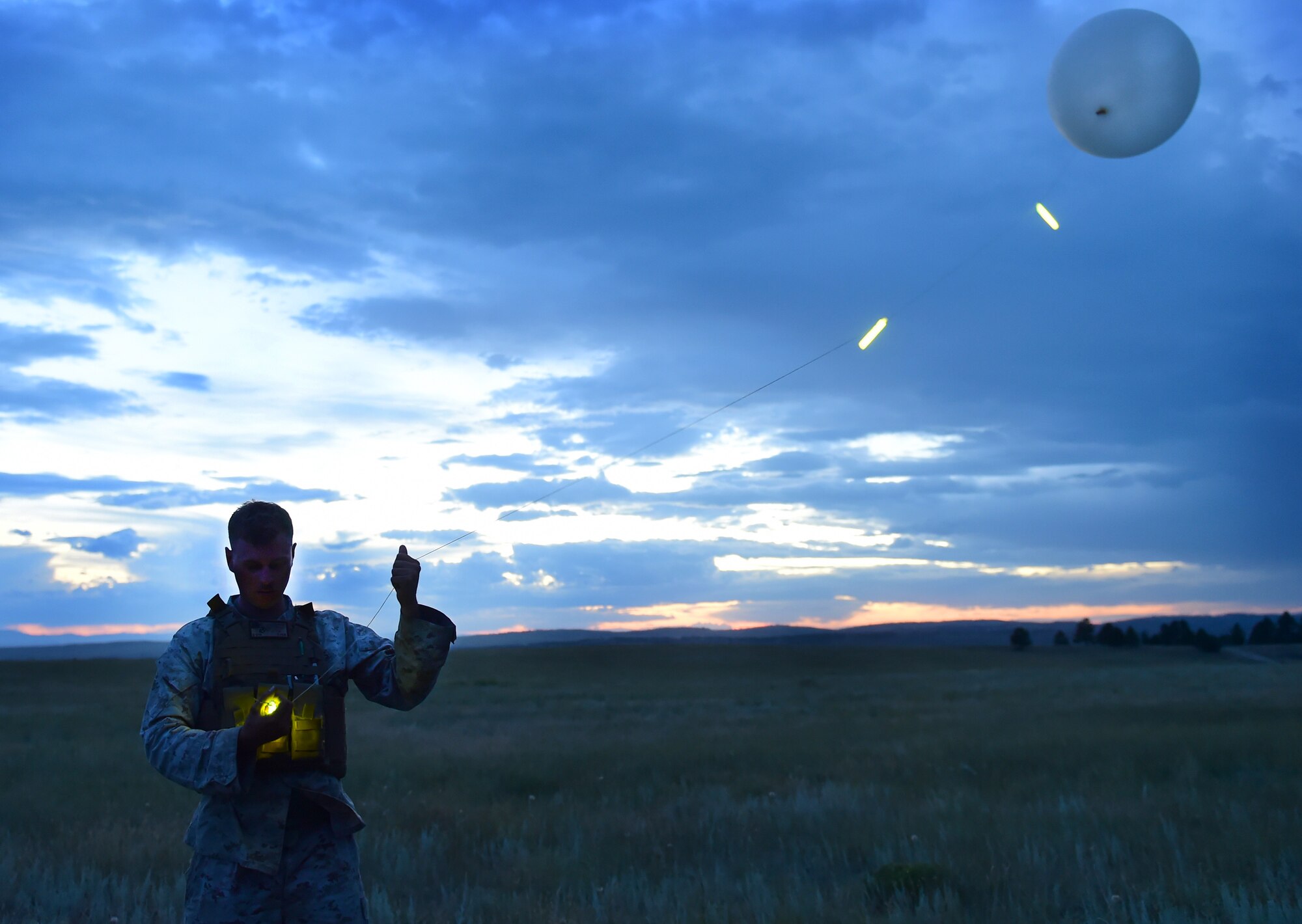 Sgt. John Frost, Quebec Battery, 5th Battalion 14 Marines fire direction center, readies a weather balloon which will allow for meteorological measurements Aug. 14, 2015, in Guernsey, Wyoming. This Marine uses meteorological equipment to collect data that will be used in the calculations that determine the angles of an artillery gun before firing. (U.S. Air Force photo by Airman 1st Class Luke W. Nowakowski/Released) 