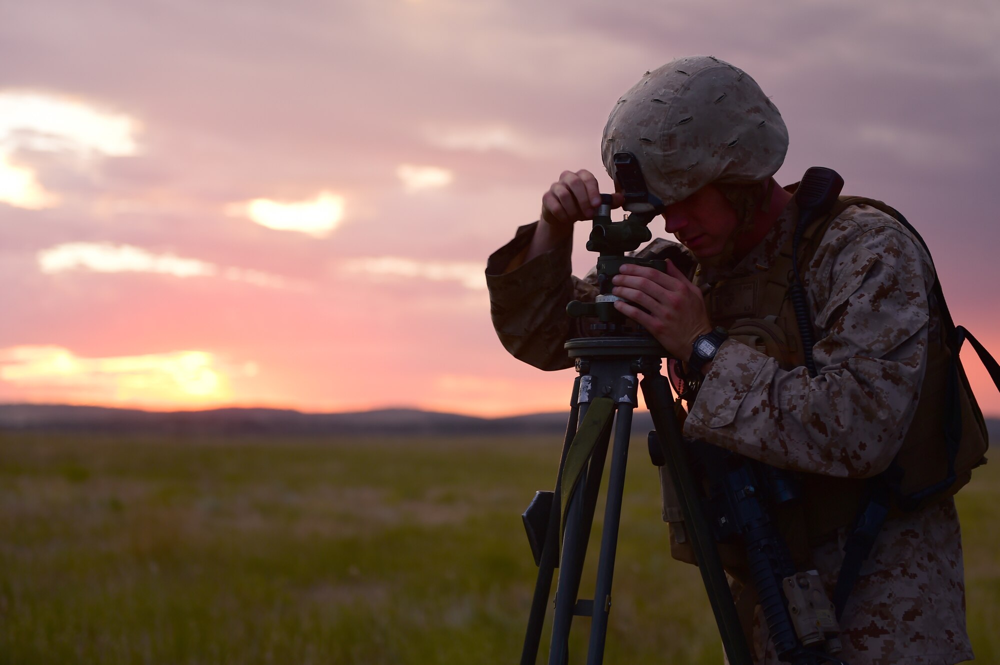 1st Lt. Alexander Purdy, 5th Battalion 14 Marines artillery officer, looks through a sight to get a calculation of where the artillery gun should be emplaced Aug. 14, 2015, in Guernsey, Wyoming. Trigonometry is used to emplace and align an artillery piece in order to ensure the most accurate fire. (U.S. Air Force photo by Airman 1st Class Luke W. Nowakowski/Released)