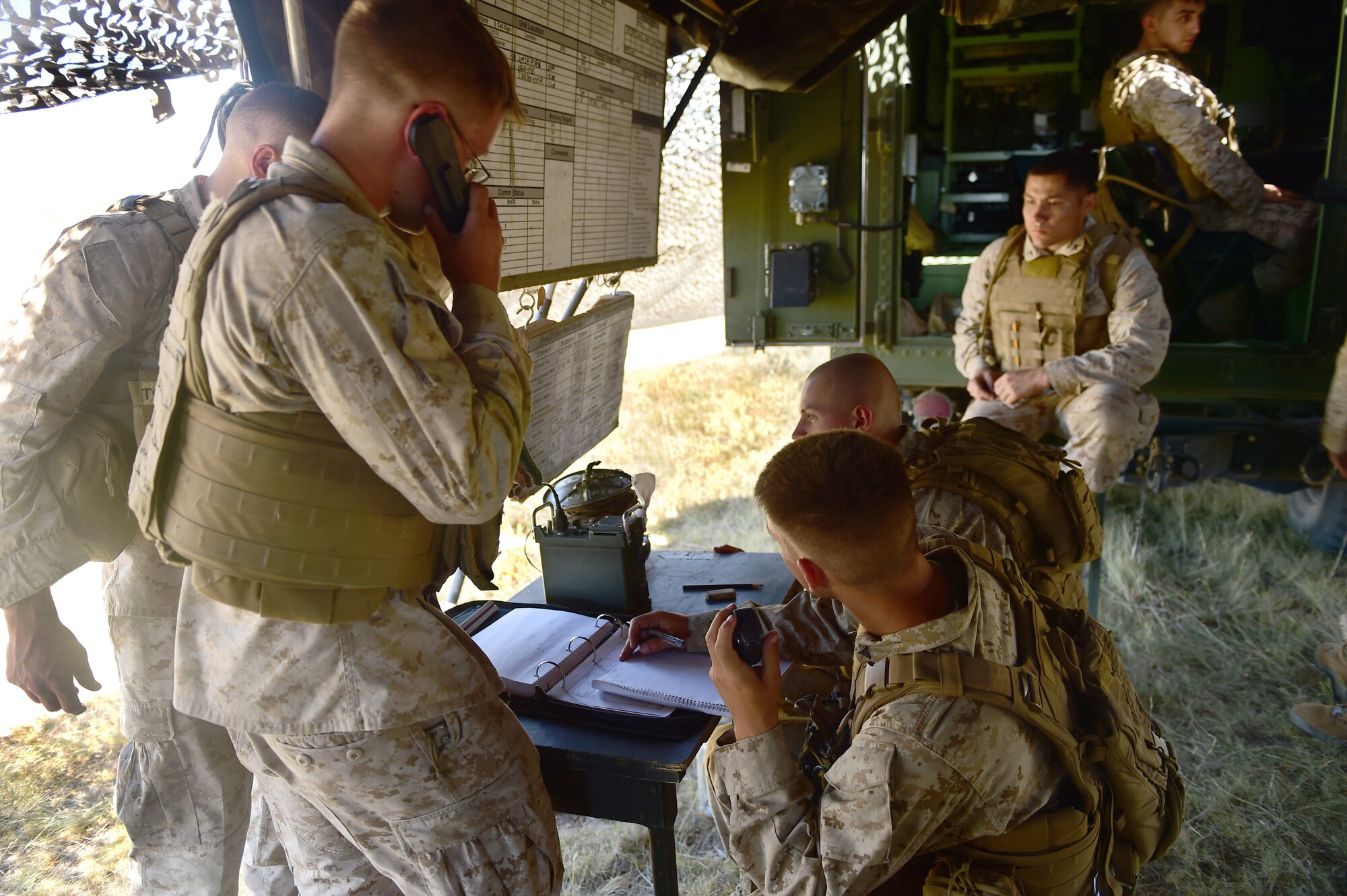 Marines from Quebec Battery, 5th Battalion 14 Marines, communicate data collected from the fire direction center to officers in the field Aug. 14, 2015, in Guernsey, Wyoming. The data collection center is the brain of an artillery battery, targeting and analyzing data from fire missions to insure the guns are firing as accurately as possible. (U.S. Air Force photo by Airman 1st Class Luke W. Nowakowski/Released)