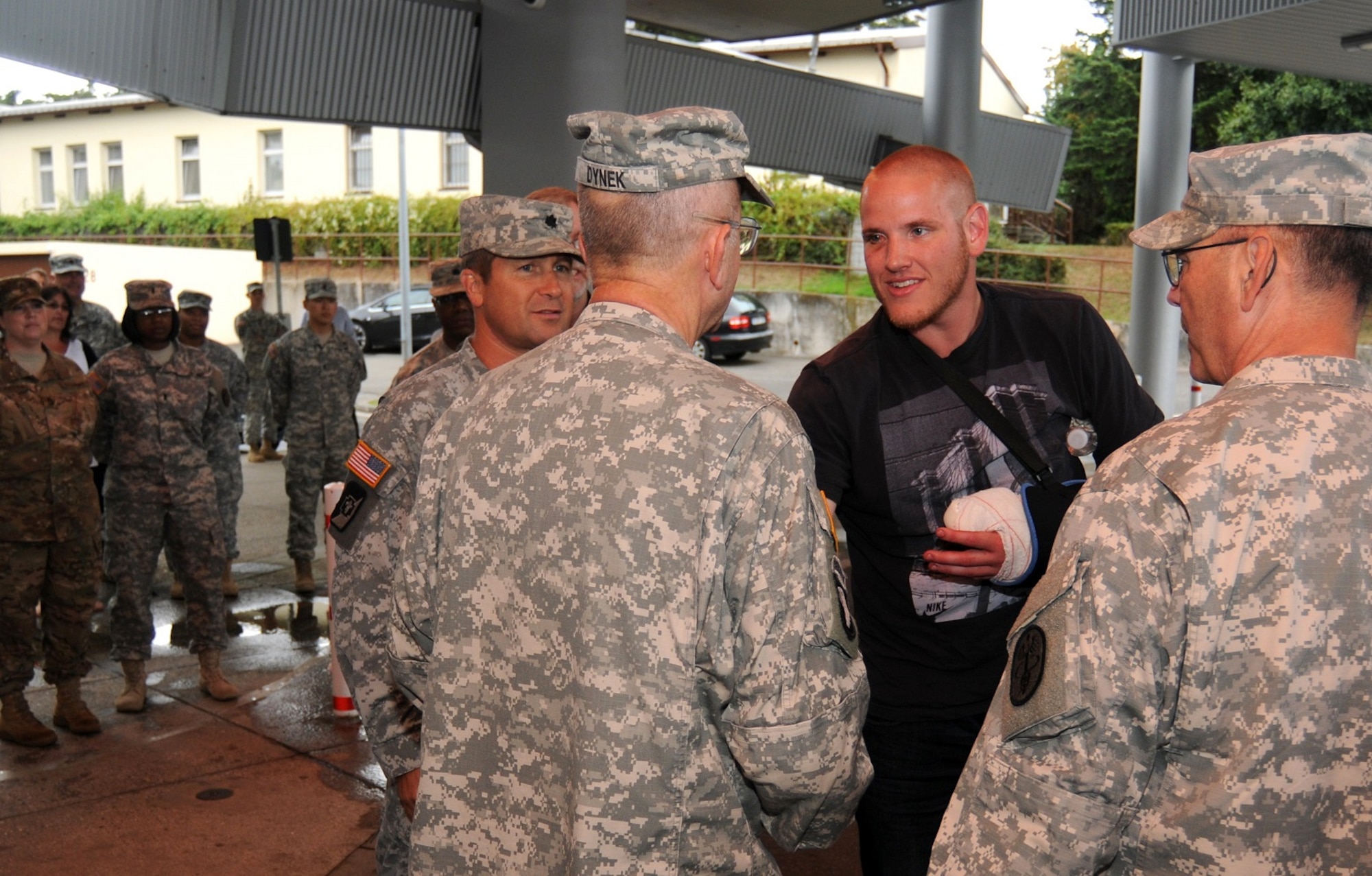 Airman 1st Class Spencer Stone shakes hands with Lt. Col. Wieslaw Dynek, chaplain, after arriving at Landstuhl Regional Medical Center, Germany, on Aug. 24, 2015. The injuries sustained by Stone while subduing an armed gunman on board a train in France will be assessed by military healthcare providers for any necessary follow-on care. Also greeting Stone are Lt. Col. Kyle Patterson (left of Dynek) and Col. Stephen Hall (right of Dynek). (U.S. Army Photo/Phil A. Jones)