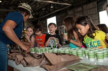 Young members from Team Seymour receive samples from Meals, Ready to Eat during the Airman and Family Readiness Center’s Operation Bug Out, Aug. 21, 2015, at Seymour Johnson Air Force Base, North Carolina. The kids also had the opportunity to try on Mission Oriented Protective Posture gear, battle rattle and flight gear. (U.S. Air Force photo/Airman Shawna L. Keyes)