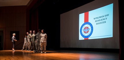 Joint Base Charleston Airmen get involved in a teambuilding exercise during a Wingman Day resiliency briefing Aug. 21, 2015, at the base theater on JB Charleston, S.C. JB Charleston held Wingman Day to highlight the four pillars of wellness; which are physical, mental, social and spiritual fitness. The Comprehensive Airman Fitness program was designed to help create additional positive behaviors in the Air Force and help Airmen, civilians and their family members become more resilient through holistic health. Wingman days are a pause in the day-to-day routine allowing Airmen to participate in the CAF program, strengthening unit health. Also part of Wingman Day, is a program called Wingman University, which offered a variety of classes to Airmen including dealing with stress in the workplace or managing a healthy lifestyle. (U.S. Air Force photo/Airman 1st Class Clayton Cupit)
