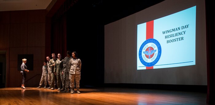 Joint Base Charleston Airmen get involved in a teambuilding exercise during a Wingman Day resiliency briefing Aug. 21, 2015, at the base theater on JB Charleston, S.C. JB Charleston held Wingman Day to highlight the four pillars of wellness; which are physical, mental, social and spiritual fitness. The Comprehensive Airman Fitness program was designed to help create additional positive behaviors in the Air Force and help Airmen, civilians and their family members become more resilient through holistic health. Wingman days are a pause in the day-to-day routine allowing Airmen to participate in the CAF program, strengthening unit health. Also part of Wingman Day, is a program called Wingman University, which offered a variety of classes to Airmen including dealing with stress in the workplace or managing a healthy lifestyle. (U.S. Air Force photo/Airman 1st Class Clayton Cupit)