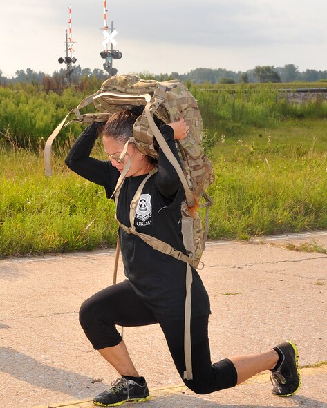 U.S. Air Force Staff Sgt. Letisha Dagraca, 55th Force Support Squadron fitness supervisor, performs squats while hiking during the Team Cohesion Challenge held on Aug. 22, 2015, at Offutt Air Force Base, Nebraska. The challenge is built around special operations training, and designed to teach leadership, promote unit cohesion and inspire teams to perform their best. (U.S. Air Force photo by D.P. Heard/Released)