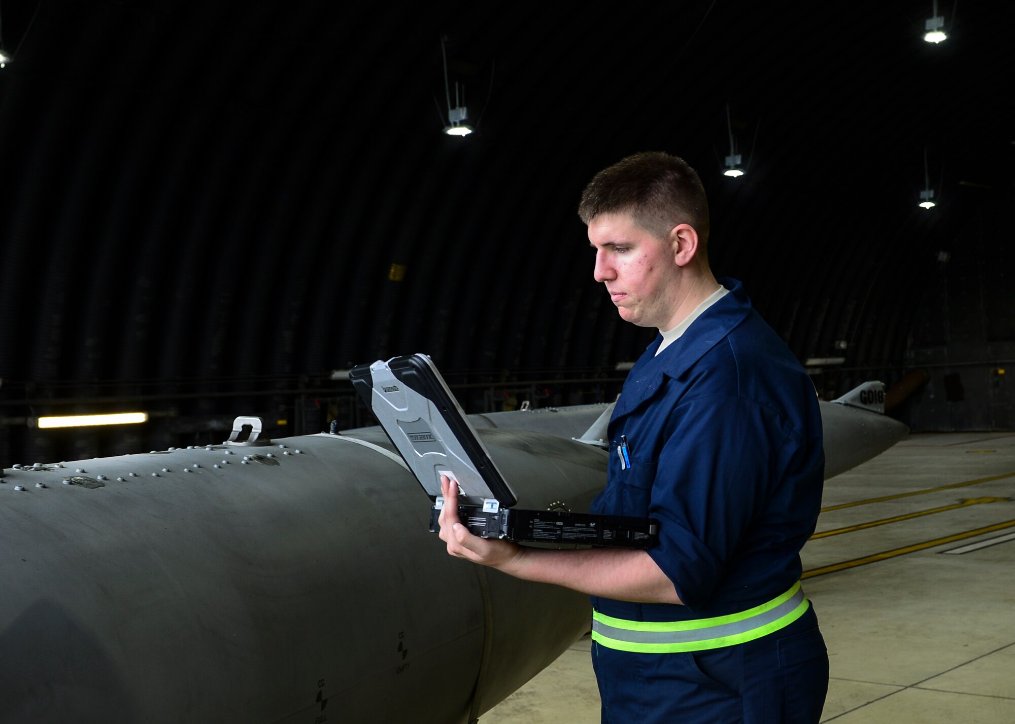 Airman 1st Class Austin Green inspects a fuselage tank on Royal Air Force Lakenheath, Aug. 21, 2015. Recent changes to the lights in the protective aircraft shelters help personnel by providing a better lit working environment. (U.S. Air Force photo by Senior Airman Nigel Sandridge/Released)