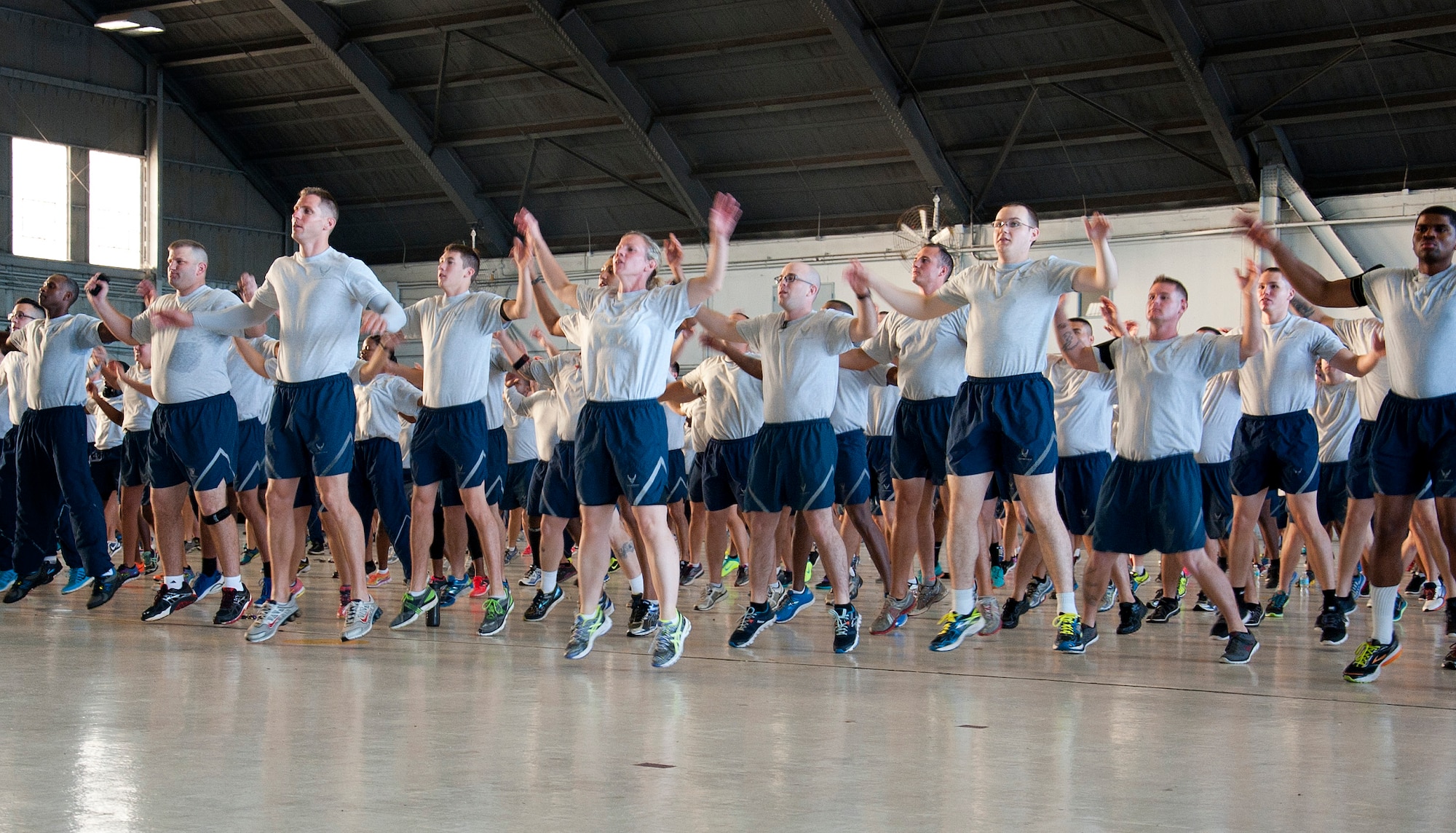Airmen from the 6th Air Mobility Wing perform jumping jacks during a warm-up workout on Wingman Day August 17, 2015, at MacDill Air Force Base, Fla. Wingman Day consisted of a flightline 5K run and small group discussions on the physical and social pillars of Comprehensive Airman Fitness. (U.S. Air Force photo by Senior Airman Jenay Randolph/Released)  