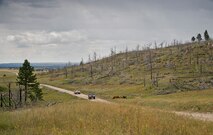 Humvees carrying 919th Special Operations Security Forces Squadron Airmen roll past cattle during the squadron’s annual training at Camp Guernsey, Wyo., Aug. 4.  More than 20 Airmen went out West to help train two other Reserve security forces squadrons in ground combat and field training.  The 919th SOSFS Airmen lived in the makeshift camps and acted as opposing forces and local villagers interacting with the occupying security teams. (U.S. Air Force photo/Tech. Sgt. Sam King)