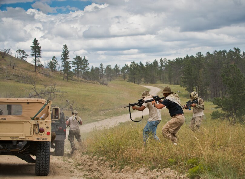 919th Special Operations Security Forces Squadron Airmen perform an ambush scenario against two vehicles during the squadron’s annual training at Camp Guernsey, Wyo., Aug. 4.  More than 20 Airmen went out West to help train two other Reserve security forces squadrons in ground combat and field training.  The 919th SOSFS Airmen lived in the makeshift camps and acted as opposing forces and local villagers interacting with the occupying security teams. (U.S. Air Force photo/Tech. Sgt. Sam King)