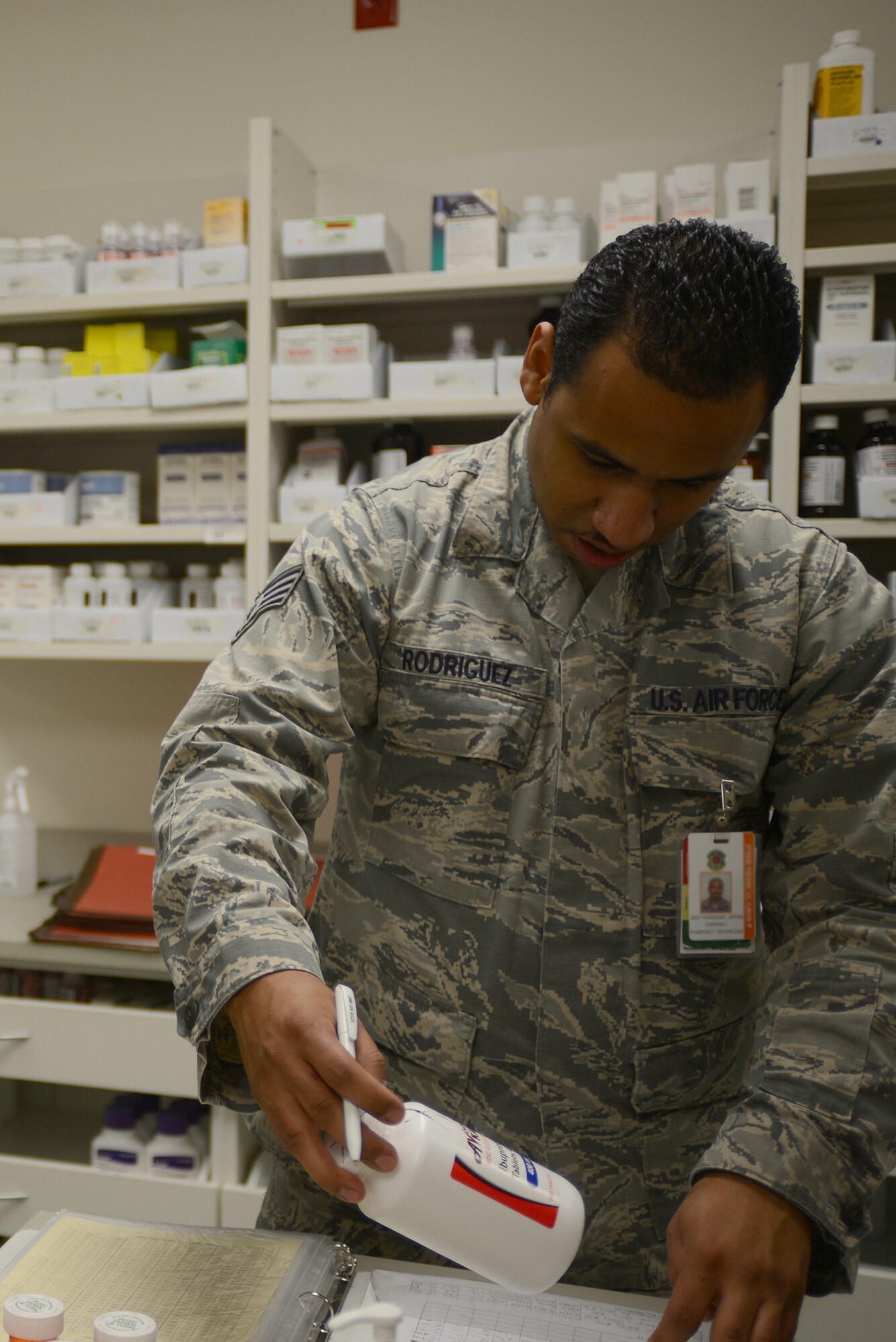 Staff Sgt. Jestin Rodriguez, 374th Medical Support Squadron pharmacy technician, annotates serial numbers for medication at Yokota Air Base, Japan, Aug. 20, 2015. Prescriptions are checked several times to ensure the medication given is accurate. (U.S. Air Force photo by Senior Airman David C. Danford/Released)