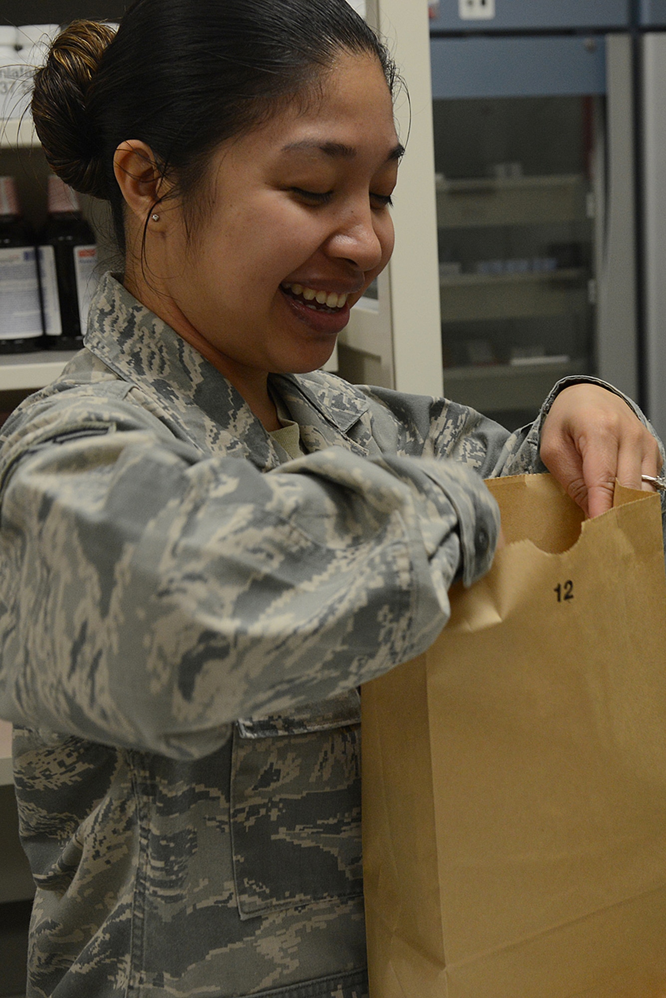 Staff Sgt. Tammi Aronce, 374th Medical Support Squadron pharmacy technician, places medication into a bag at Yokota Air Base, Japan, Aug. 20, 2015. The pharmacy serves 11,000 beneficiaries, including active duty service members, dependents and civilians. (U.S. Air Force photo by Senior Airman David C. Danford/Released)