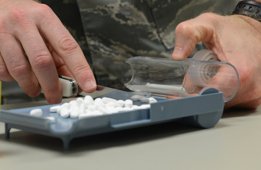 Lt. Col. Matt Cowan, 374th Medical Support Squadron diagnostic and therapeutics flight commander, counts tablets for a prescription at Yokota Air Base, Japan, Aug. 19, 2015. Prescriptions are checked several times to ensure the medication given is accurate. (U.S. Air Force photo by Senior Airman David C. Danford/Released)