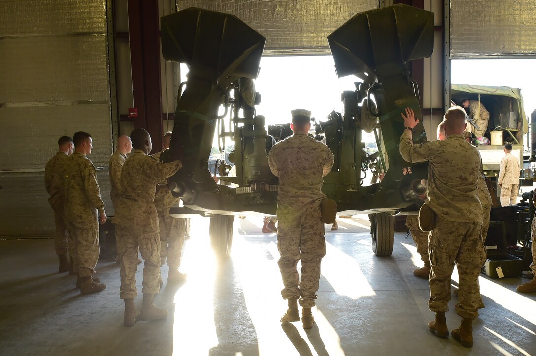 Marines from Quebec Battery, 5th Battalion 14 Marines, push a M777 A2 Howitzer toward an awaiting truck to be hauled up to Camp Guernsey, Wyoming, Aug. 13, 2015, on Buckley Air Force Base, Colo. Q Battery is a Marine reserve unit that stages out Buckley AFB and conducted a three-day live fire exercise in Guernsey, Wyoming. (U.S. Air Force photo by Airman 1st Class Luke W. Nowakowski/Released)