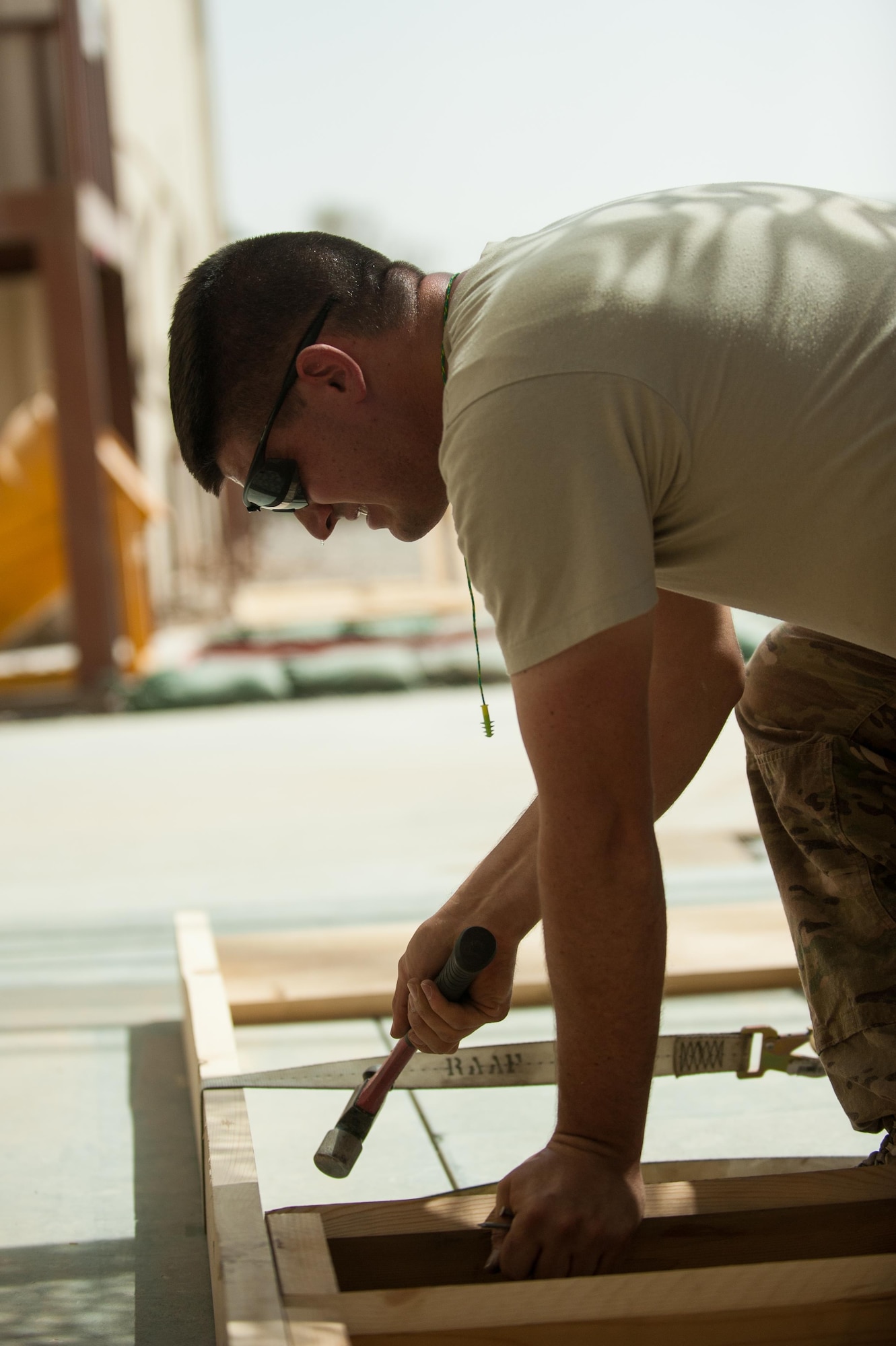 U.S. Air Force Tech. Sgt. Dallan Livingston, 451st Expeditionary Support Squadron Central Command Material Recovery Element air transportation specialist, builds a set of stairs for a defensive fighting position at Kandahar Airfield, Afghanistan, Aug. 15, 2015.  Livingston has been using his carpentry skills during his spare time to build projects to better KAF. (U.S. Air Force photo by Tech. Sgt. Joseph Swafford/Released)