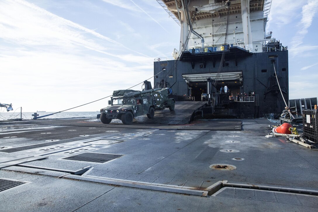A Marine with Combat Logistics Regiment 25 drives a High Mobility Multipurpose Wheeled Vehicle (HMMWV) off of the USNS 1st Lt. Jack Lummus and onto a Roll-on/Roll-off Discharge Facility , during an in-stream Marine Prepositioning Force Exercise, Aug. 19, 2015. Marines with CLR-25 and sailors with Naval Beach Group 2 joined forces for the latest iteration of MPFEX, which saw service members offloading the Lummus using Lift-on/Lift-Off and Roll-on/Roll-off procedures off the coast of Marine Corps Support Facility Blount Island, Fla. (U.S. Marine Corps photo by Sgt. Shawn Valosin/Released)