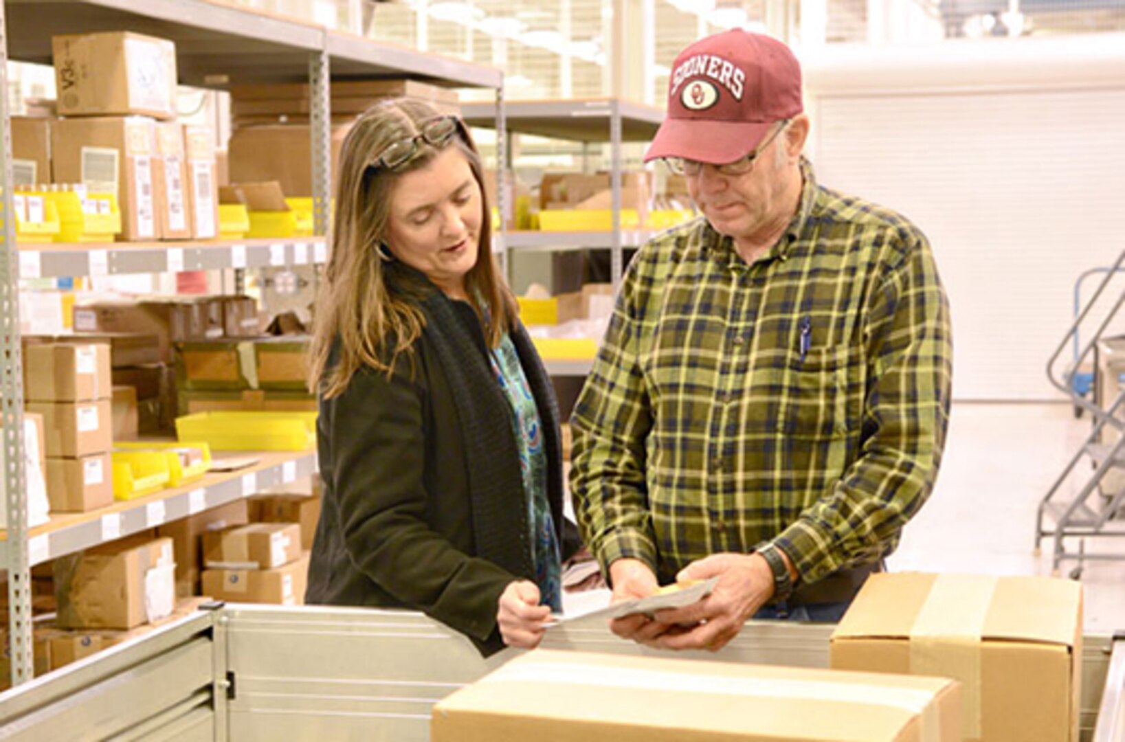Brenda Price, a Defense Logistics Agency Aviation materials expeditor supervisor, and Kenneth Watkins, another materials expeditor, verify a part before shipping it to a customer Feb. 6.