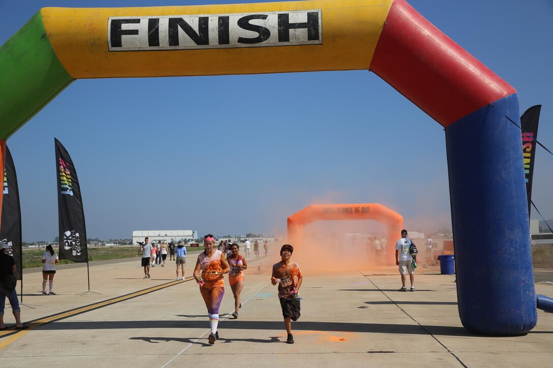 Participants cross the finish line after completing the Color Me Rad 5k San Diego aboard Marine Corps Air Station Miramar, California, Aug. 22. The event was hosted by MCAS Miramar on its flight line.  (U.S. Marine photo by Lance Cpl. Kimberlyn Adams/Released)