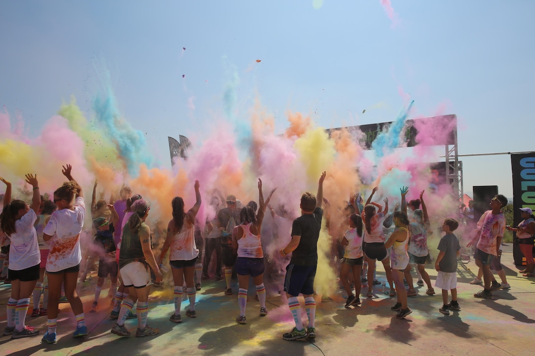 Participants throw color bombs in the air after completing the Color Me Rad 5k San Diego aboard Marine Corps Air Station Miramar, California, Aug. 22. The event was hosted by MCAS Miramar on its flight line. (U.S. Marine photo by Lance Cpl. Kimberlyn Adams/Released)
