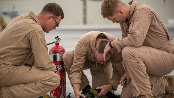Cpl. Mason Stone, left, a KC-130J crewmaster, Staff Sgt. David Hoyt, middle, a KC-130J loadmaster, and Cpl. Greg Gambrell, right, a KC-130J crewmaster, set up the refueling site for air delivery ground refueling training aboard Marine Corps Air Station Iwakuni, Japan, Aug. 21, 2015. Marine Aerial Refueler Transport Squadron 152 uses this training to make sure their Marines are able to proficiently use all of the KC-130J’s assets. 