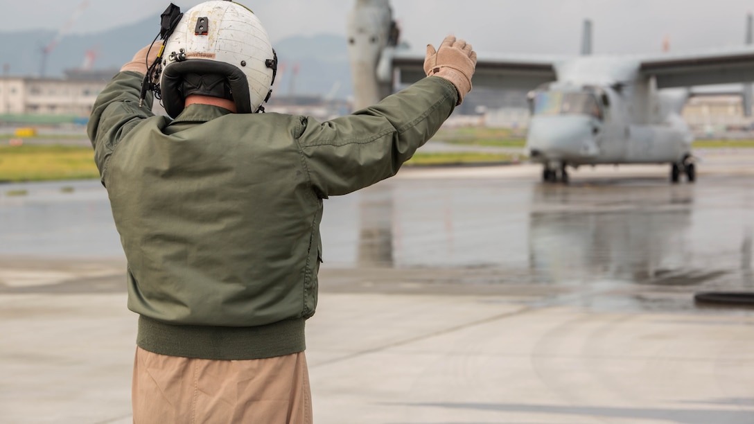 Staff Sgt. David Hoyt, a KC-130J loadmaster with Marine Aerial Refueler Transport Squadron(VMGR) 152, guides a MV-22B Osprey tiltrotor aircraft with Marine Medium Tiltrotor Squadron 262, into place for air-delivery ground refueling training aboard Marine Corps Air Station Iwakuni, Japan, Aug. 21, 2015. This kind of refueling operation is usually conducted in an austere environment where an air strip or fuel is not available. The KC-130J’s ability to refuel other vehicles adheres to the Marine Corps aviation’s mission to deliver Marines, fuel and cargo where needed. 