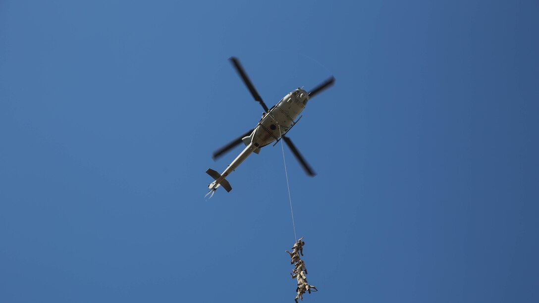 Marines from Company A, 1st Reconnaissance Battalion, 1st Marine Divison, I Marine Expeditionary Force, are suspended from a UH-1Y Huey helicopter during an exercise on Marine Corps Base Camp Pendleton, Calif., Aug. 18, 2015. Utilizing both fast-roping and Special Patrol Insertion and Extraction rigging methods, the purpose of the training exercise was to integrate operational coordination between the I MEF Ground Combat Element and Air Combat Element. 