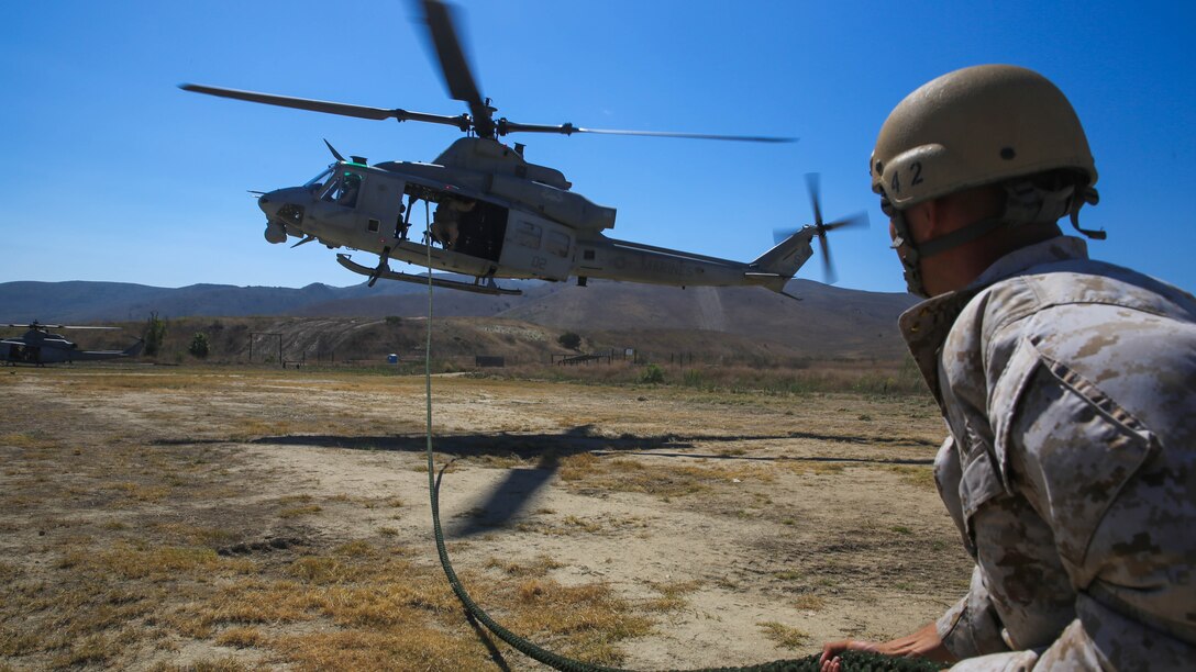 Mechanicsburg, Pa., native Gunnery Sgt. Daniel Young, a platoon sergeant with Company A, 1st Reconnaissance Battalion, 1st Marine Division, I Marine Expeditionary Force, draws a fast-roping line out from underneath a UH-1Y Huey helicopter during a training exercise on Marine Corps Base Camp Pendleton, Calif., Aug. 18, 2015. Utilizing both fast-roping and Special Patrol Insertion and Extraction rigging methods, the purpose of the training exercise was to integrate operational coordination between the I MEF Ground Combat Element and Air Combat Element.