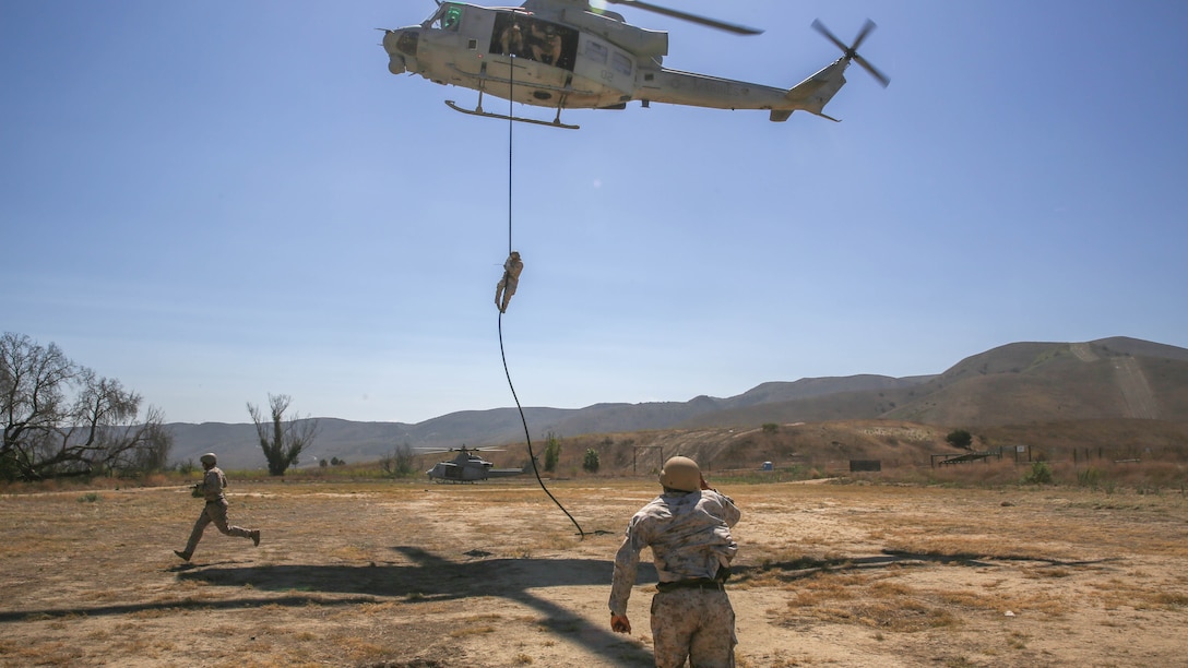 Mechanicsburg, Pa., native Gunnery Sgt. Daniel Young, a platoon sergeant with Company A, 1st Reconnaissance Battalion, 1st Marine Division, I Marine Expeditionary Force, runs to grab the rope underneath a UH-1Y Huey helicopter during a training exercise on Marine Corps Base Camp Pendleton, Calif., Aug. 18, 2015. Utilizing both fast-roping and Special Patrol Insertion and Extraction rigging methods, the purpose of the training exercise was to integrate operational coordination between the I MEF Ground Combat Element and Air Combat Element. 