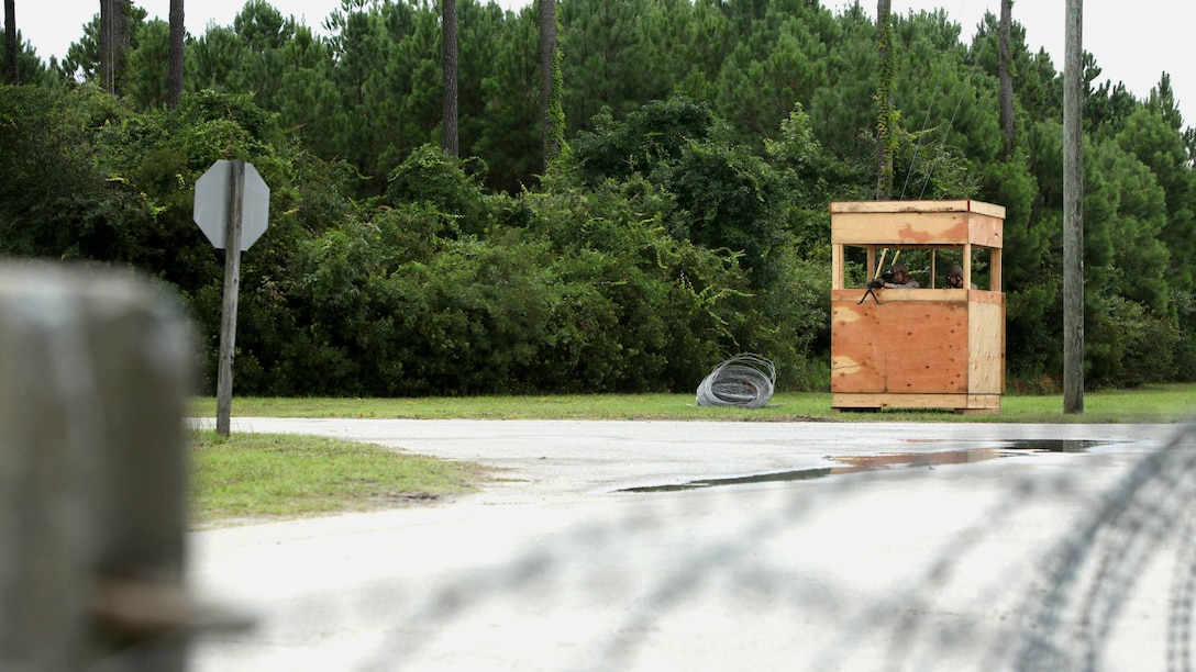 Cpl. Steele Hartmann, left, and Lance Cpl. Daniel Lark, stand their post, sighting down the entry control point during an airbase ground defense field operation at Marine Corps Auxiliary Landing Field Bogue, North Carolina, Aug. 19, 2015. Nearly 300 Marines with Marine Wing Support Squadron 271 were involved in the field operation by providing security for ground operations during portrayed enemy attacks. Hartmann is a combat engineer and Lark is an aircraft rescue and firefighting specialist, both with MWSS-271.