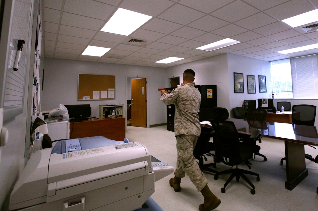 Capt. Eric Meeder scans a room during a Marine Air Control Group 28 Headquarters and Marine Tactical Air Command Squadron 28 anti-terrorism force protection program training event at Marine Corps Air Station Cherry Point, North Carolina, Aug. 20, 2015. Meeder is the anti-terrorism force protection officer for MTACS-28. (U.S. Marine Corps photo by Pfc. Nicholas P. Baird/ released) 