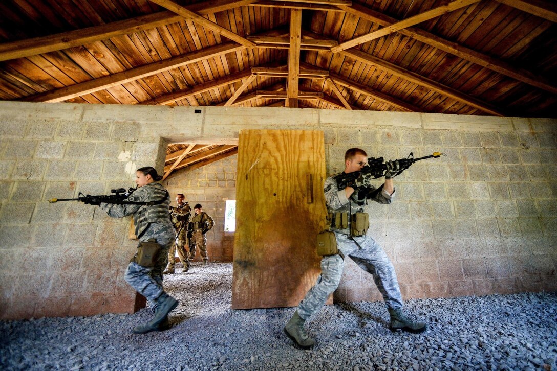 U.S. Airmen secure a room during medical evacuation drills during a biannual tactical combat casualty care course on Ramstein Air Base, Germany, Aug. 5, 2015. More than 20 Airmen from the 435th Contingency Response Support Squadron, 435th Security Forces Squadron and 86th Medical Group participated in the training.