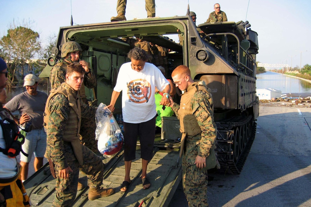 Marines assist Evelin Jenkins out of their assault amphibian vehicle in New Orleans, Sept. 7, 2005. Jenkins waited 8 days before agreeing to be evacuated from the ruins of Hurricane Katrina. Courtesy photo
