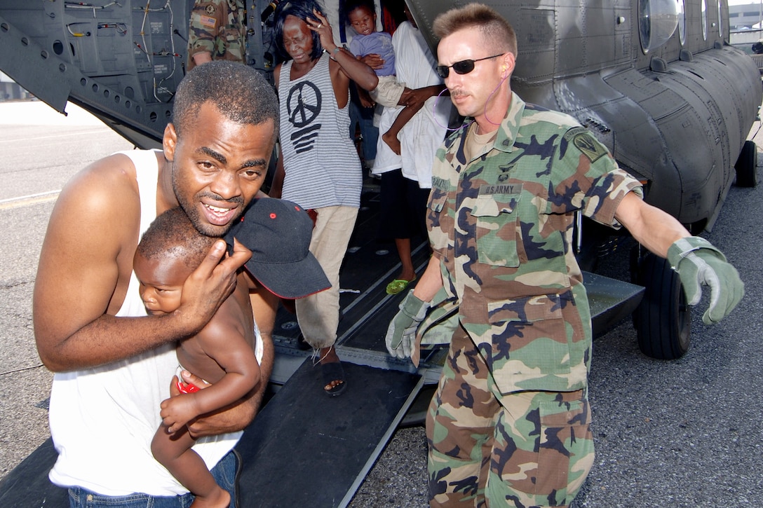 A soldier directs Hurricane Katrina victims as they exit the back of an Army CH-47 Chinook helicopter during relief efforts in New Orleans, Sept. 3, 2005. The soldier is an Army National Guard air crewman. Army guardsmen were mobilized to take part in Joint Task Force Katrina, a humanitarian assistance operation led by the Federal Emergency Management Agency in conjunction with the Defense Department. U.S. Navy photo by Petty Officer 1st Class Robert McRill
