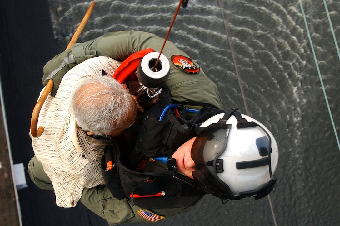 U.S. Navy Petty Officer 1st Class Tim Hawkins evacuates a victim of Hurricane Katrina from a rooftop into an SH-60B Seahawk helicopter in New Orleans, Sept. 5, 2005. Hawkins is a search-and-rescue  swimmer. U.S. Navy photo by Petty Officer 3rd Class Jay C. Pugh