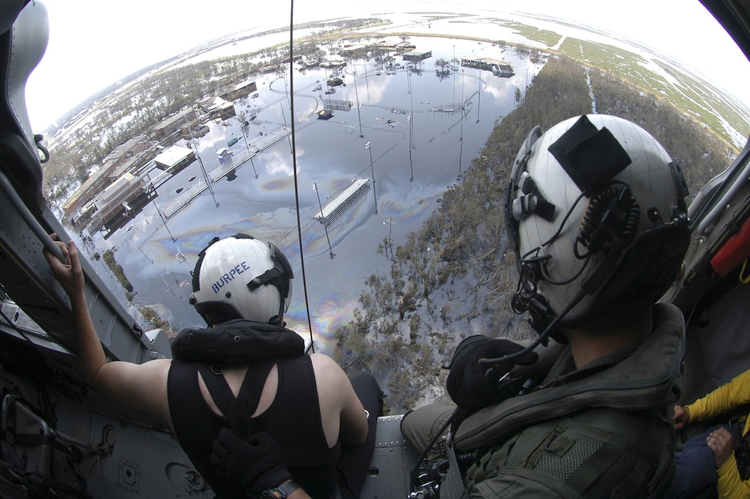 Airmen on a search-and-rescue operation observe a rescue in progress along the Louisiana coast Aug. 31, 2005. The airmen were assigned to Helicopter Sea Combat Squadron 28HSC 28 from the USS Bataan, which was in the Gulf of Mexico about 100 miles south of New Orleans. The Defense Department mobilized to support the Federal Emergency Management Agency's disaster-relief efforts in the Gulf Coast areas devastated by Hurricane Katrina. U.S. Navy photo by Airman Jeremy L. Grisham