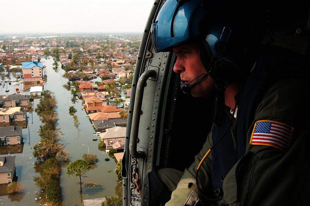 Coast Guard Petty Officer 2nd Class Shawn Beaty looks for survivors in the wake of Hurricane Katrina in New Orleans, Aug. 30, 2005.  Beaty is a member of an HH-60 Jayhawk helicopter rescue crew sent from Clearwater, Fla., to assist. U.S. Coast Guard photo by Petty Officer 2nd Class NyxoLyno Cangemi